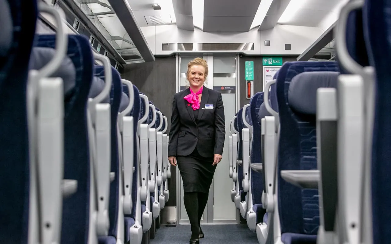 Hull Trains Paragon first class host walking down the carriage
