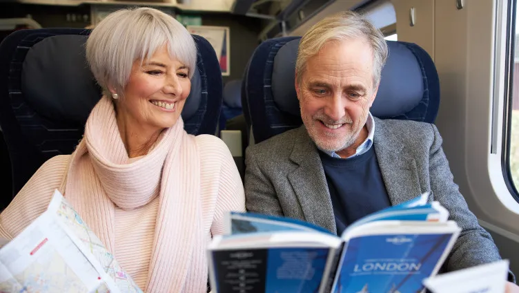 couple looking at travel book in first class