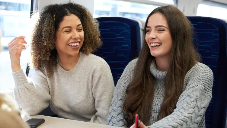 friends laughing together on board a train