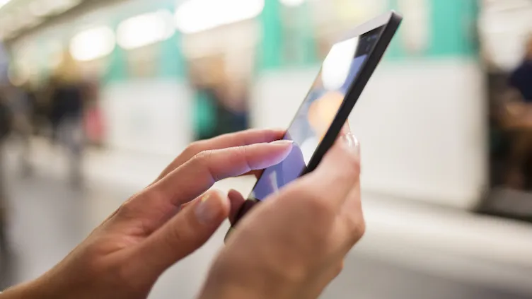 person using mobile in station