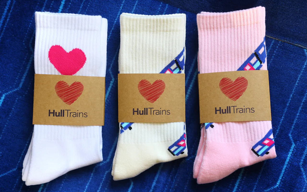 A photo of 3 types of Hull Trains socks placed on a seat onboard a Hull Trains service